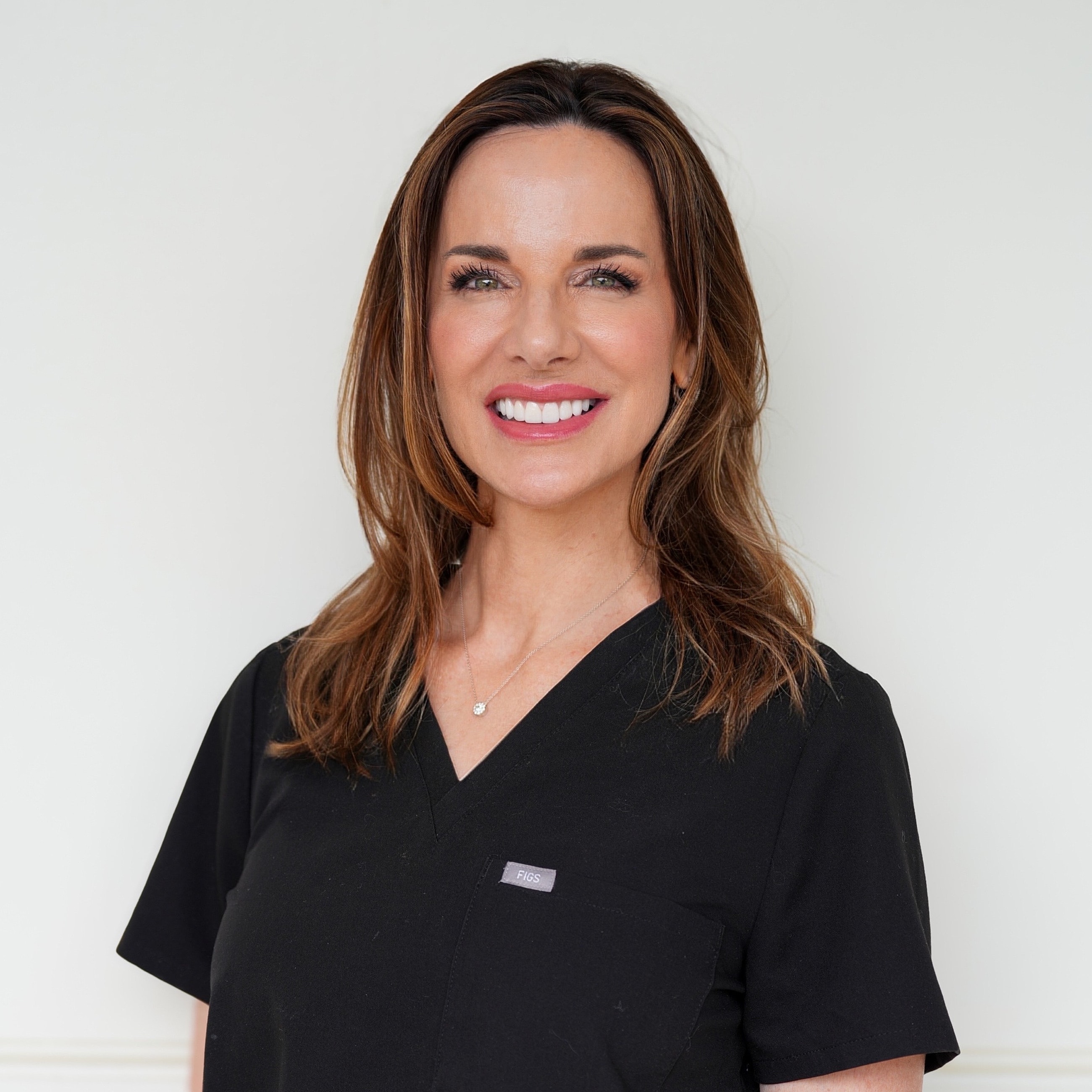 Smiling woman in medical scrubs.