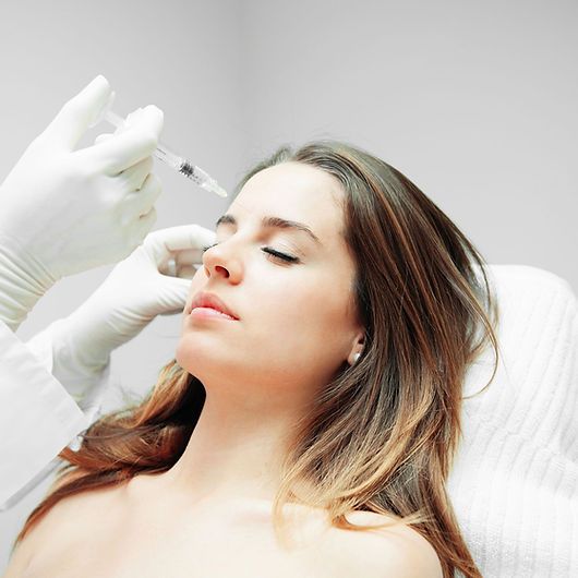 Woman receiving cosmetic treatment in clinic.