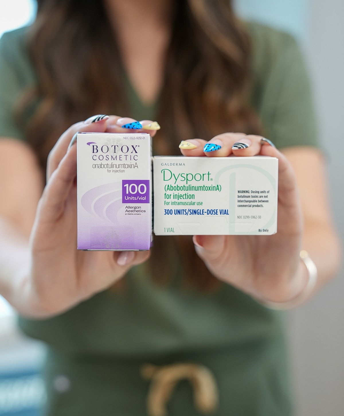Botox and Dysport injection products held by model