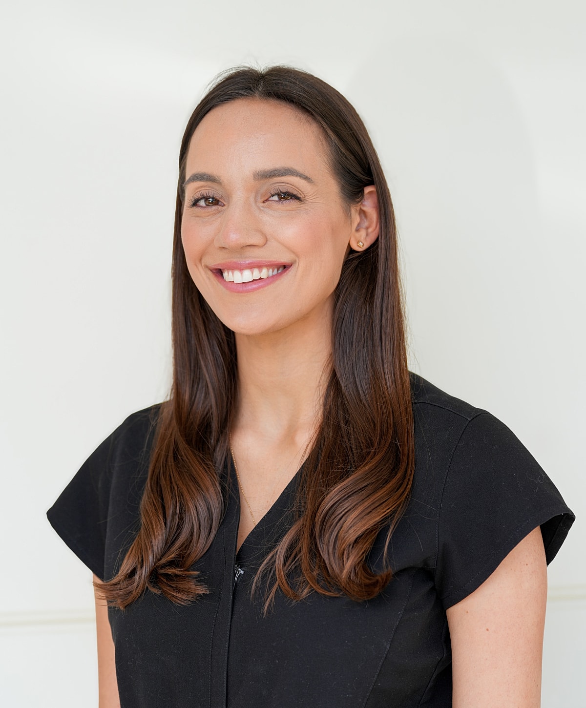 Smiling woman with long hair in black top.