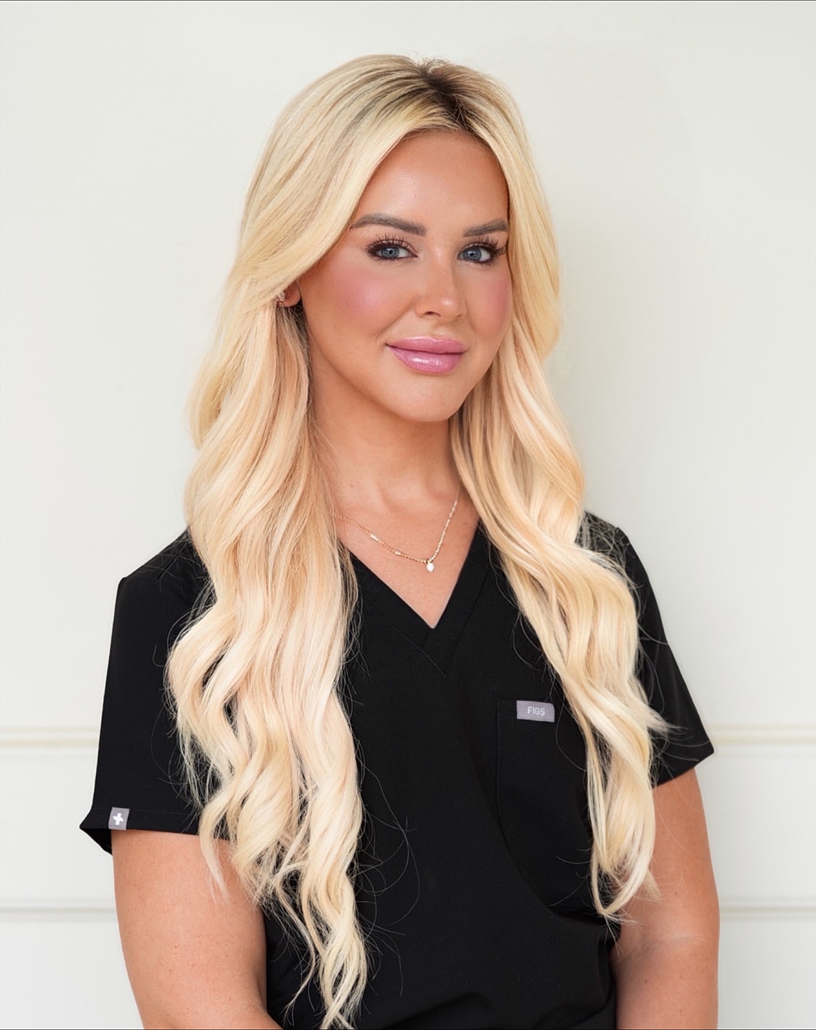Woman in scrubs with long blonde hair.
