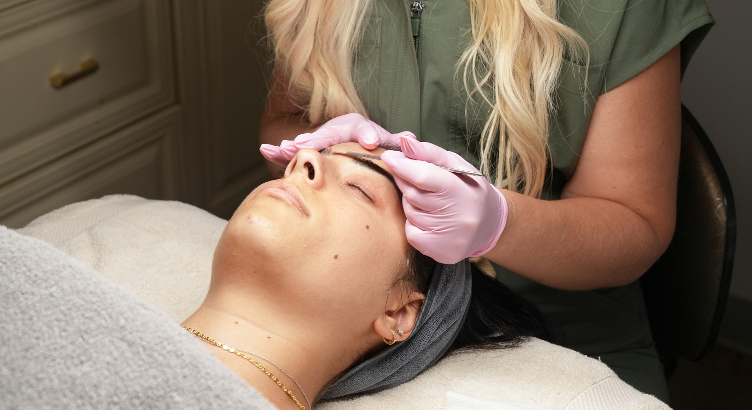 Facial treatment with practitioner wearing pink gloves.